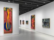installation view, brightly colored tall paintings in a gallery with white walls