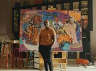 Artist Amani Lewis stands in front of work in promo video for google partnership to promo black-owned businesses