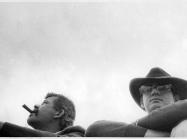 John Chamberlain and Larry Bell at the motorcycle races, Bridgehampton NY,1966. black and white, only their heads are visible