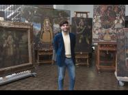 José Luis Lazarte Luna, Assistant Conservator in Paintings Conservation, who was born and raised in Lima, Peru, stands in front of several paintings in the Cuzco School style that were recently gifted to The Met 