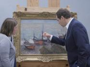 two museum workers study monet up close