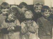 group of small children close their eyes in prayer