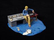small model of a man at a desk with blue carpeting