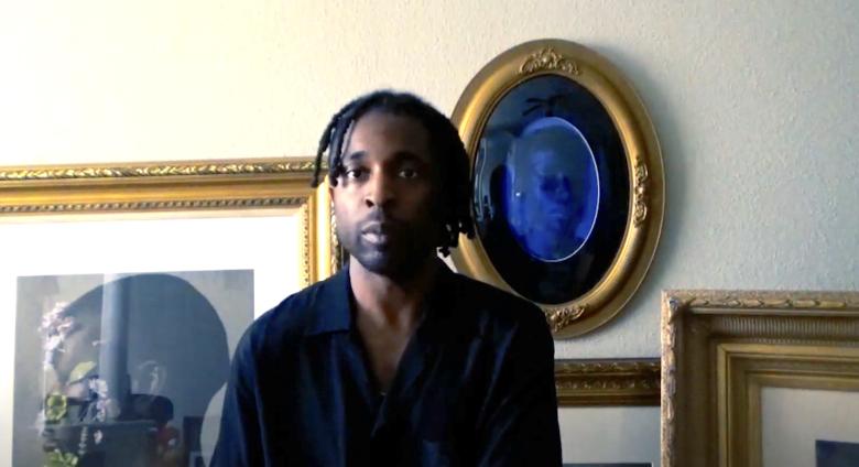 image of Fagan in front of pictures looking at camera