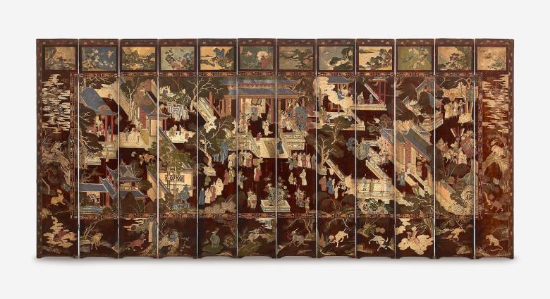 Folding screen, dark burgundy and intricately decorated to show a courtyard with Chinese structures and pavilions and garden features wit people mingling about.    