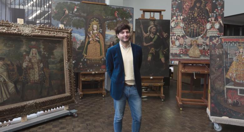 José Luis Lazarte Luna, Assistant Conservator in Paintings Conservation, who was born and raised in Lima, Peru, stands in front of several paintings in the Cuzco School style that were recently gifted to The Met 