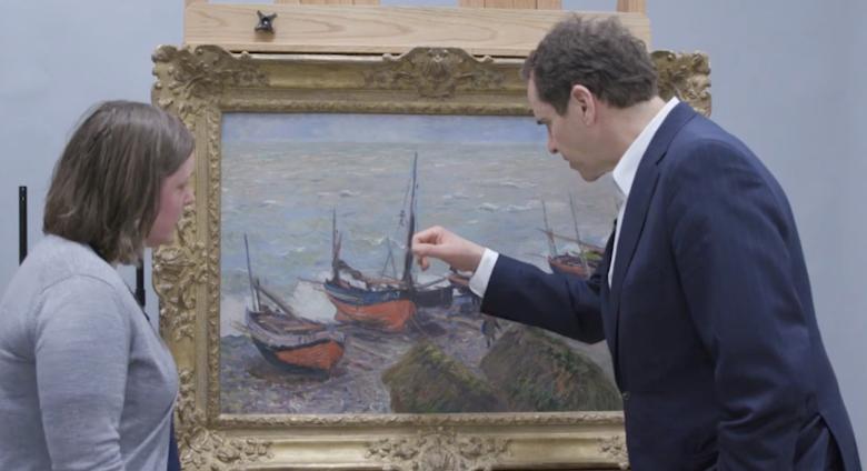 two museum workers study monet up close