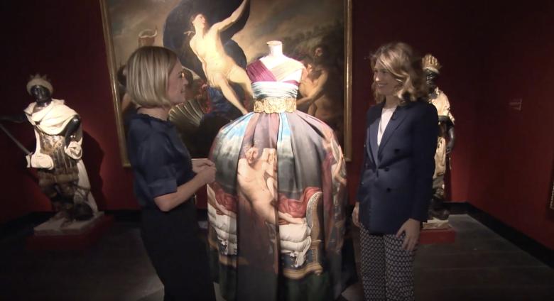 Examining dress with painting in background