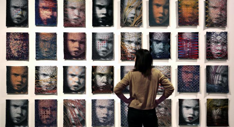 A wall of 32 woven portraits 
