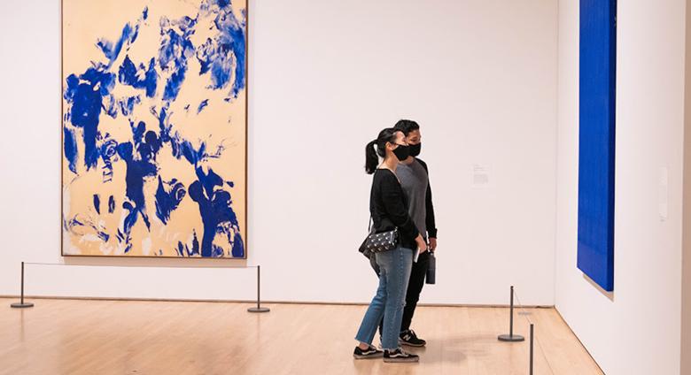 Visitors inside of SFMOMA, looking at paintings 