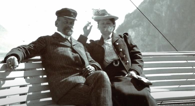 Photograph of Wilhelm and Henny Hansen smoking in front of water 