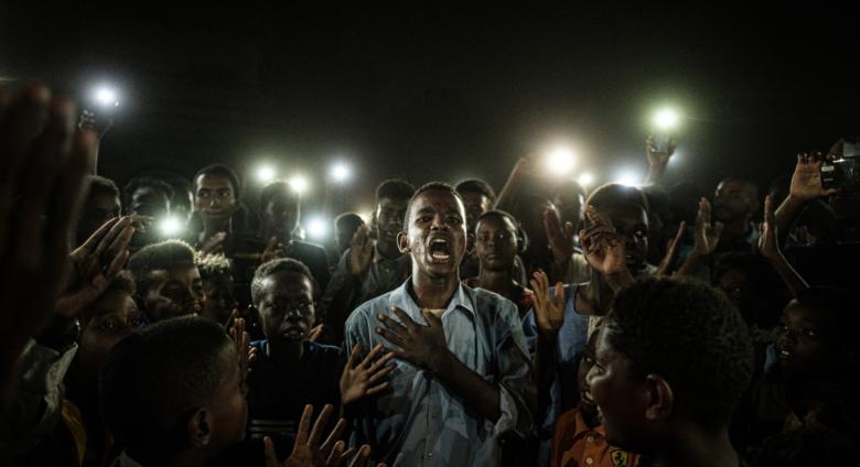 a young man at the center of crowd cries out