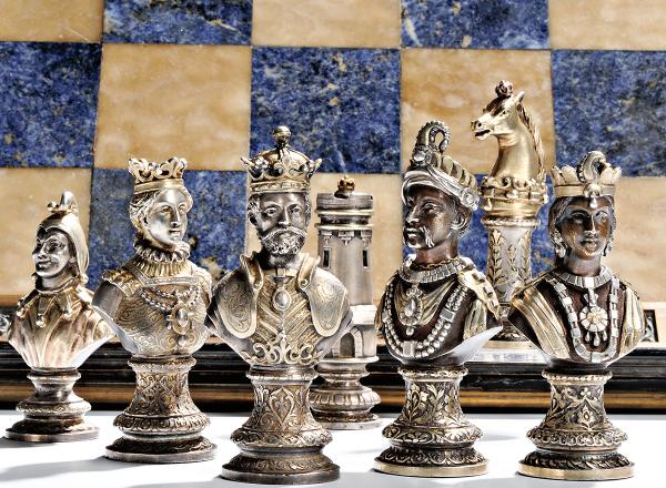 silver chess set in front of a blue and cream stone board