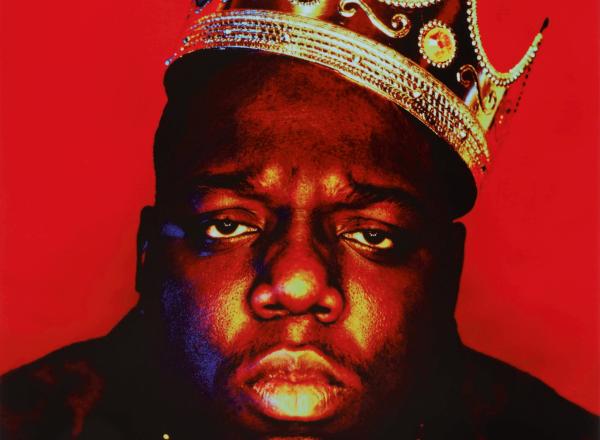 Portrait of Notorious BIG wearing a plastic crown in front of a red background