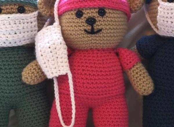 three crocheted teddy bears in scrubs and face masks