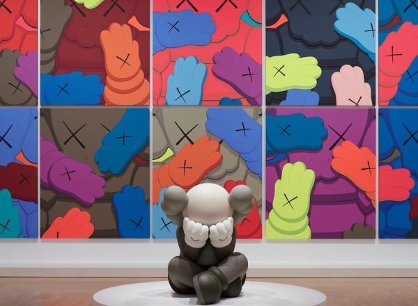 Installation view, KAWS: WHAT PARTY, Brooklyn Museum, February 26, 2021 - September 5, 2021. Features sculpture in front of a series of several flat images of 