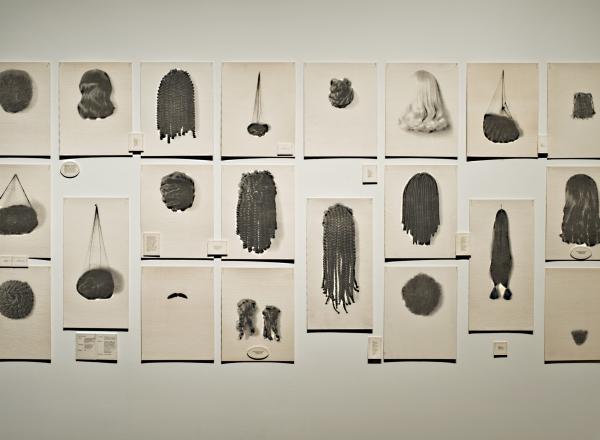 Lorna Simpson art installation of 20 images of wigs hung on a wall