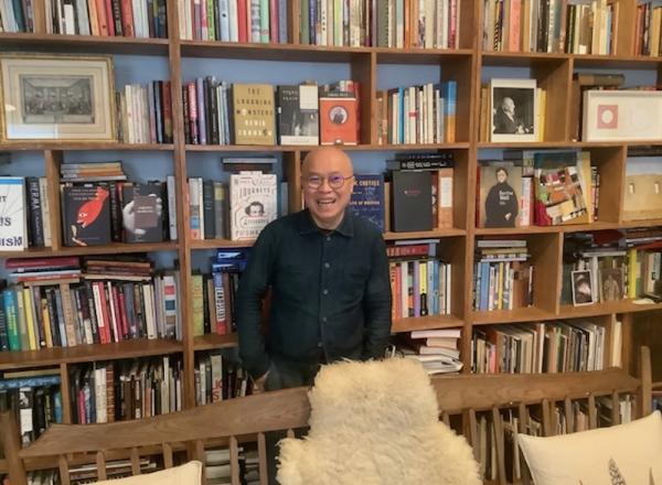Phong Bui in front of his many bookshelves. 