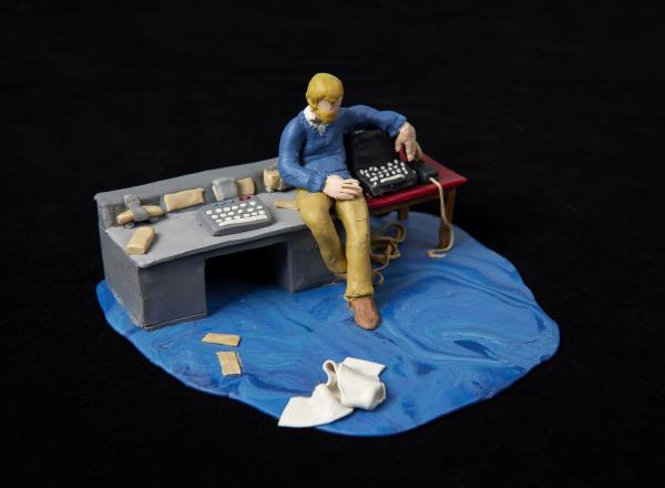 small model of a man at a desk with blue carpeting