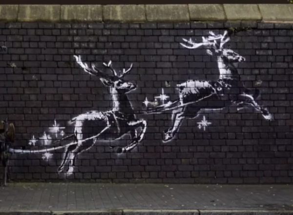 banksy mural of reindeer pulling a public bench