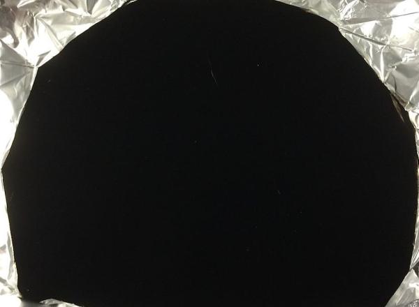 Wrinkled aluminium foil with a portion—equally wrinkled—coated in Vantablack. Courtesy Wikimedia Commons. Photo Anna Frodesiak and Surrey NanoSystems.