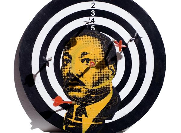 a dart board with martin luther king's portrait screenprinted on top in orange and black. 