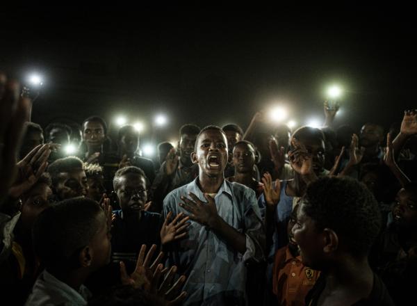 a young man at the center of crowd cries out