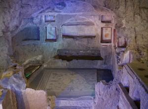 The large family tomb, cut into the rock of the hillside, with painted frescos and mosaic paving.