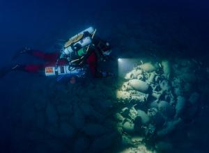 An archeologist examines an underwater site. Source.