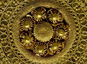 Detail shot of a gold ear-stud: disc decorated with granulation, filigree and beaded wire. 530BC-500BC