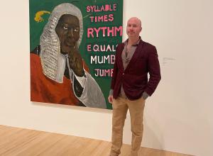 Jeffrey Magid standing in front of Henry Taylor's / was King When I Met the Queen, Syllable x Rythm Equals Mumbo Jumbo, 2013.