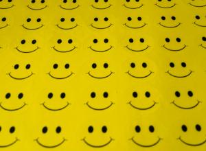 a sheet of yellow fabric with rows and rows of smiley faces