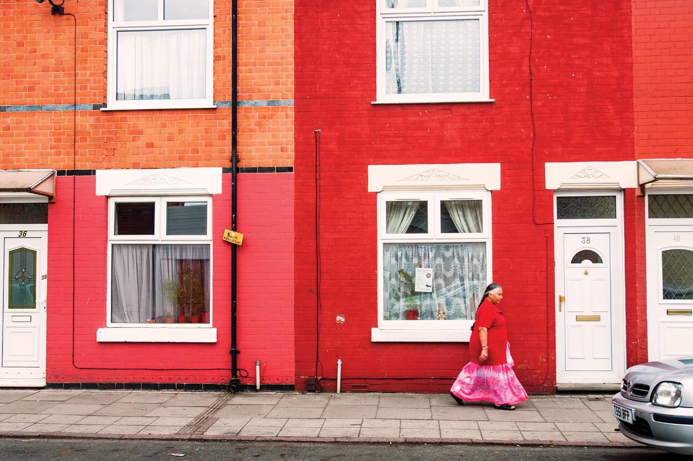 Pablo Bartholomew, "Gujarati Woman in a Saree Walks Past Red Brick Homes in her Neighborhood, Leicester, UK," 2011
