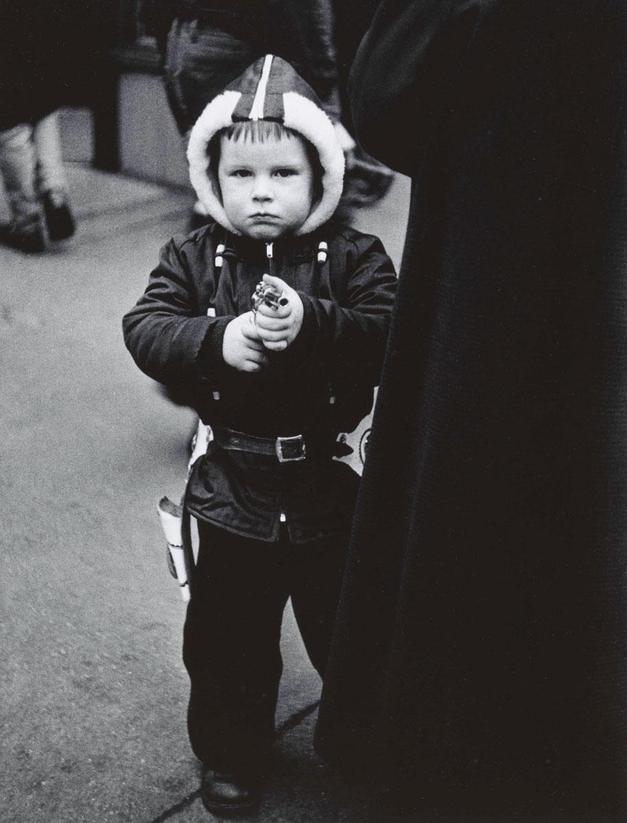 Kid in a hooded jacket aiming a gun, N.Y.C. 1957
