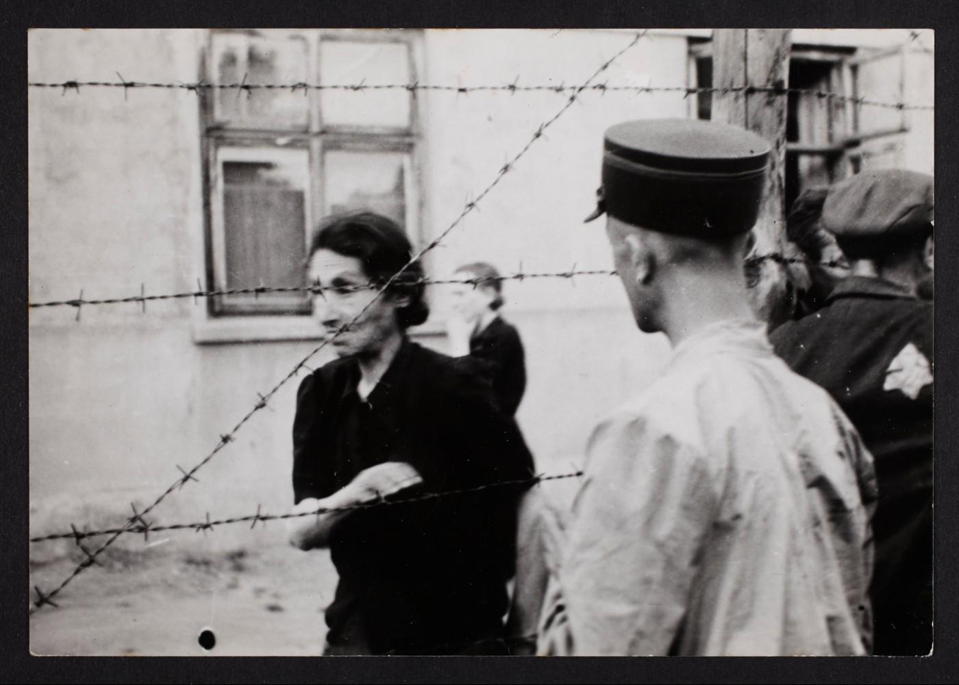 Henryk Ross, Ghetto police with woman behind barbed wire, 1940-1944