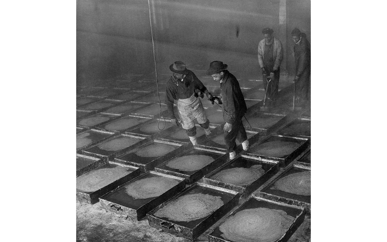 Gordon Parks, Two workmen pulling pans of red hot grease that has just been poured from a cooking kettle. After it is cooled it can be lifted out in solid chunks and carried away on flat cars, March 1944.