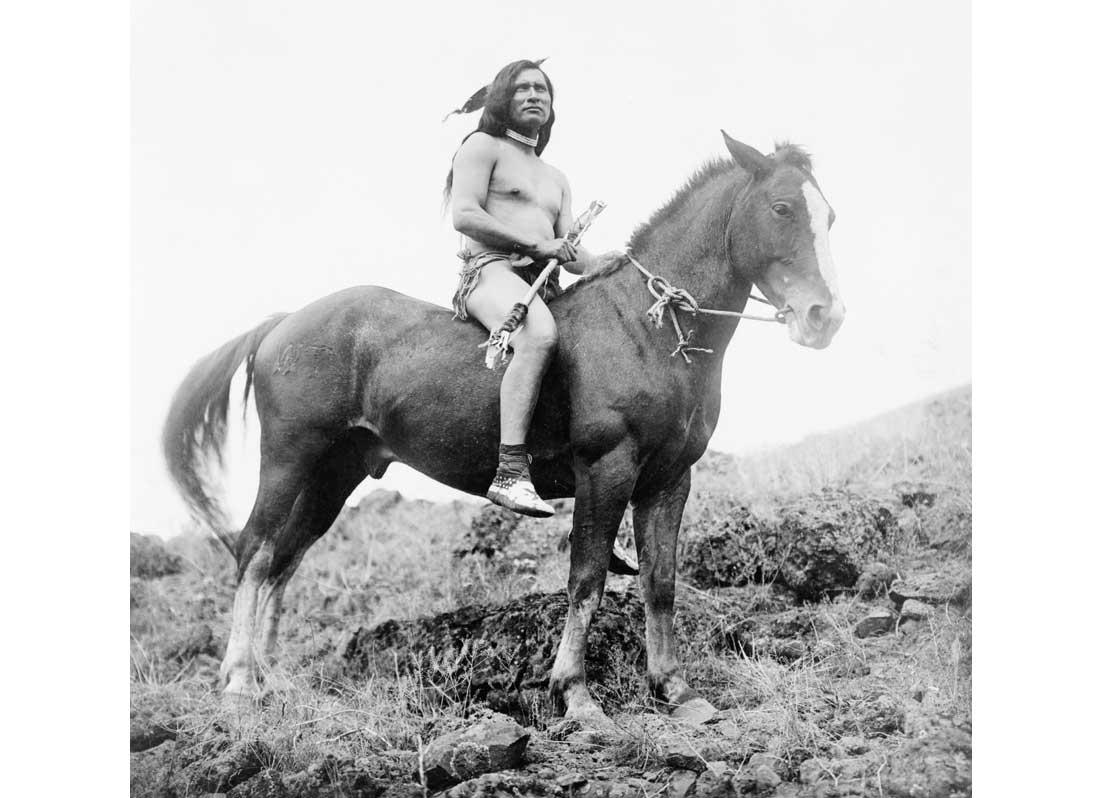 Nez Percé man, wearing loin cloth and moccasins, on horseback, 1910.