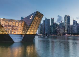 Illuminated polyhedral building Louis Vuitton over the water at Marina Bay in the evening, with skyscrapers of the Central Business District in the background, Singapore. License