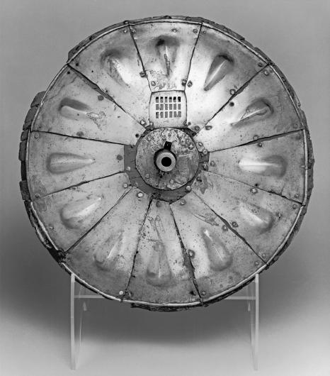 Gun shield, round segmented metal.