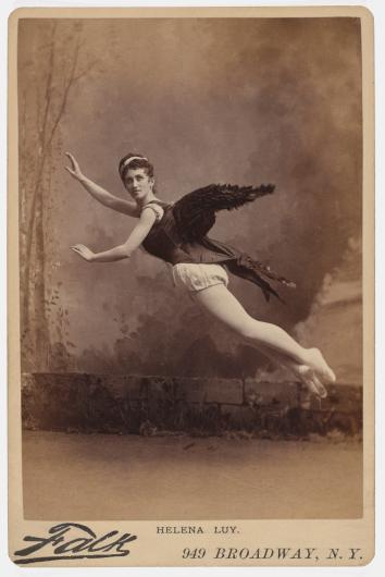 antique photograph of a woman with angel wings in a photography studio