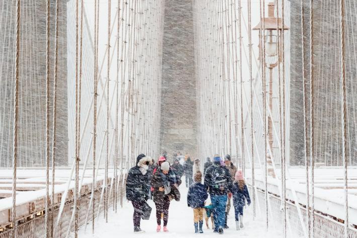 People walk on a bridge during a blizzard