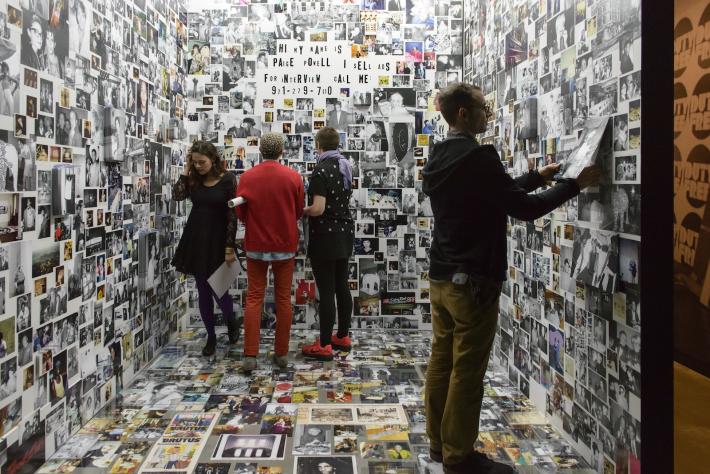 Exhibit view, visitors with images on wall