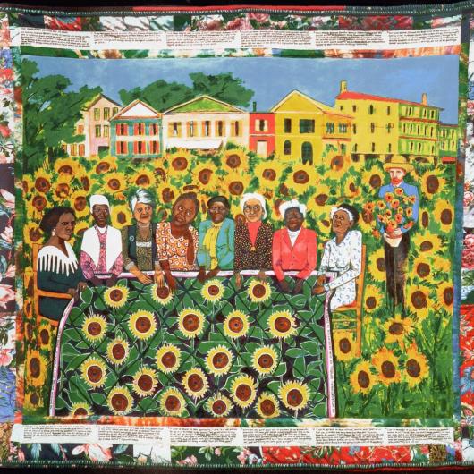 quilt featuring women working on a quilt with sunflower field. Van gough stands off to the side. 