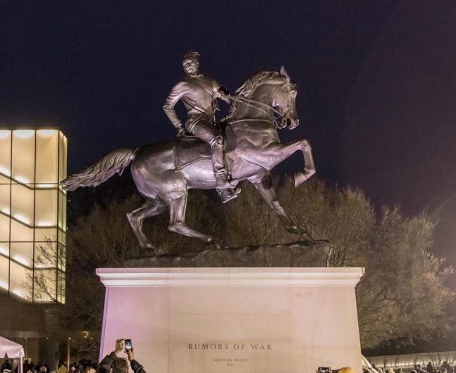 monumental equestrian statue with black man in sweatshirt 