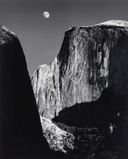 Ansel Adams black and white photograph of the moon over a rocky cliff face during the day