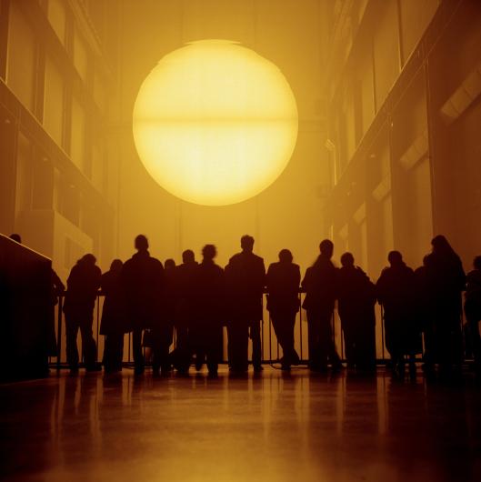 PETER MARLOW photograph of crowds standing before an Olafur Eliasson installation of a large, bright sun in the Tate Modern art museum