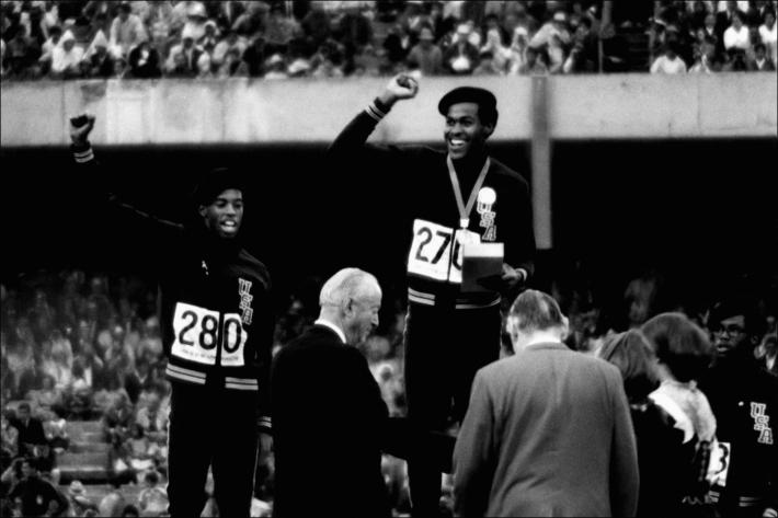 Raymond Depardon black and white photograph of American athletes Larry James, Lee Evans and Ron Freeman on the winner’s podium for the 400-meter relay at the 1968 Olympic Games