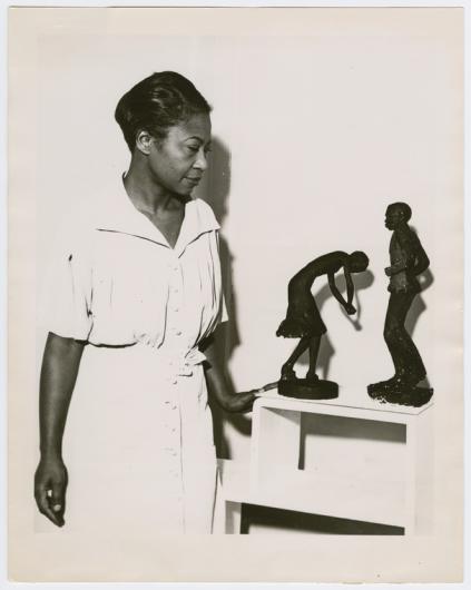 Sculptor Augusta Savage with two of her statuettes (left to right) Susie Q and Truckin' in 1939.