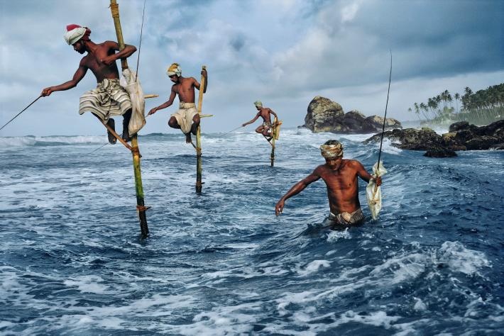 STEVE MCCURRY photograph of Sri Lankan fisherman on stilts in the ocean