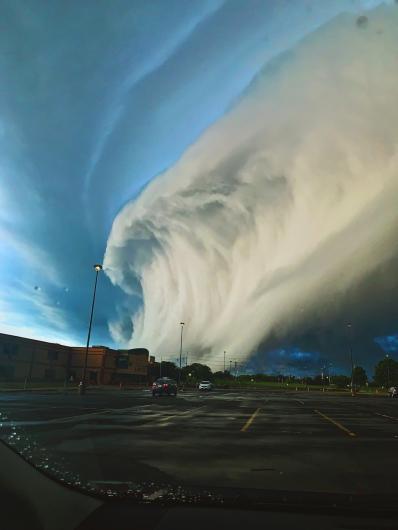 a large wave-shaped cloud over a city